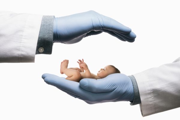 Mãos de médico segurando um bebê