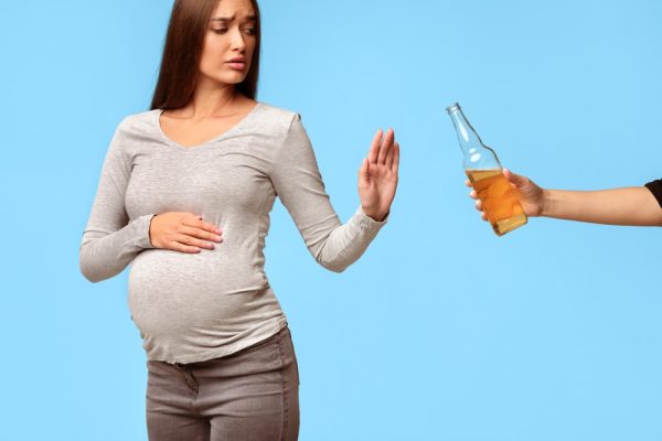 Mulher grávida negando bebida alcoólica.