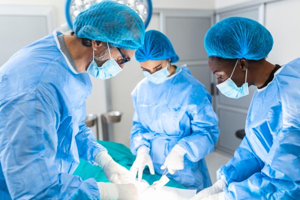 Médicos realizando cirurgia em sala cirúrgica.