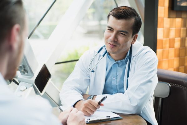 Homem em consulta com um médico.