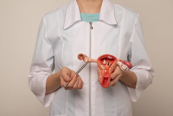 Médica explicando Exame ALICE segurando um óvulo de plástico