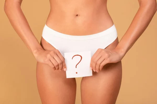 mulher com placa de "?" para apresentar falta de menstruação por conta de amenorreia