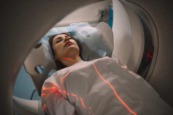 Mulher no aparelho para fazer a ressonância magnética.