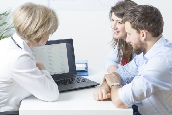 Casal em consulta com médica mulher.