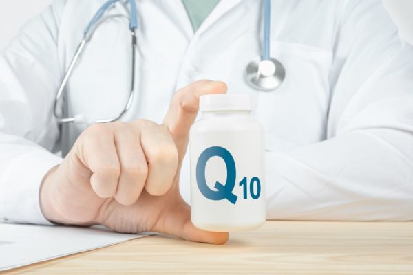 Médico segurando um frasco de coenzima Q10.