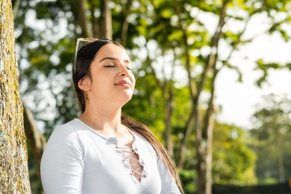 Mulher relaxando ao ar livre representando formas de controlar a ansiedade durante a FIV.