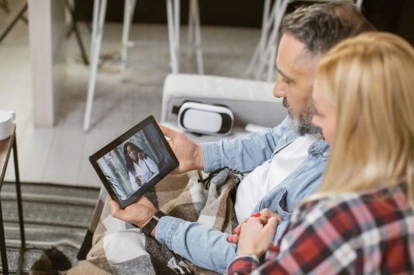 Casal em teleconsulta com médica representando a FIV a distância.