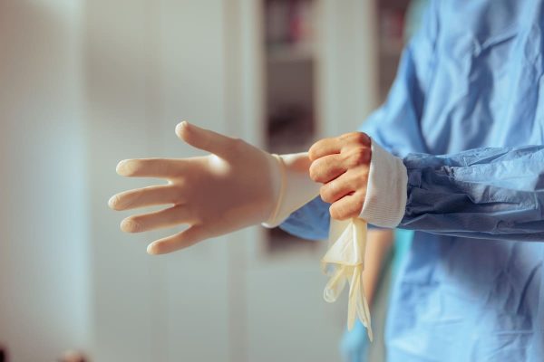 Médica vestindo luva de borracha ilustrando procedimento de transfusão intrauterina de plaquetas em falhas de implantação recorrentes.