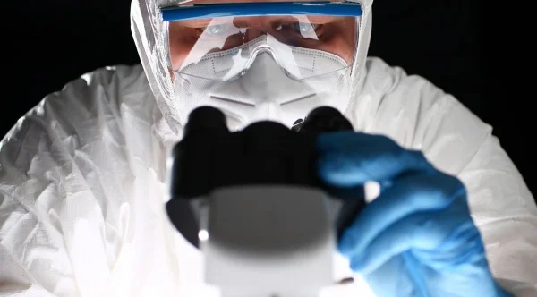 Médico em laboratório com microscópio representando estratégias para aumentar as chances de gravidez na FIV.