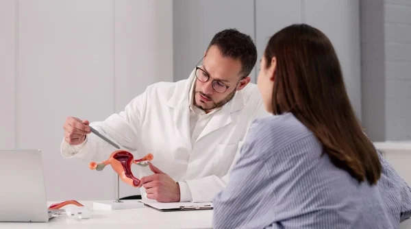 Médico explicando com réplica de útero ilustrando a relação entre mioma uterino e fertilidade.