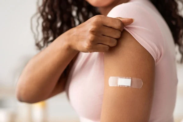 Mulher com curativo no braço representando vacinas obrigatórias antes da Fertilização in Vitro.