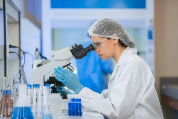 Embriologista trabalhando em laboratório ilustrando aspectos envolvidos ao trocar de clínica de fertilização in vitro.